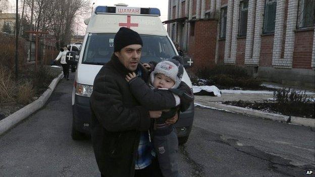 A man carries a child after shelling in a residential area of the town of Artemivsk, Ukraine - 13 February 2015