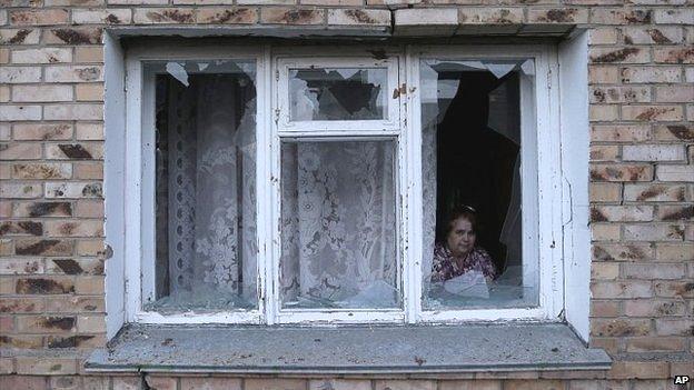 A resident looks out of her damaged windows after shelling in a residential area of Artemivsk in eastern Ukraine - 13 February 2015