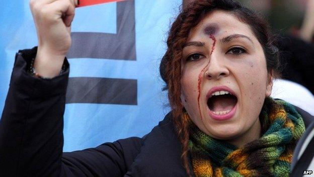 A woman with a bullet hole painted on her forehead takes part in a demonstration against the murder of 20-year-old Ozgecan Aslan, who was killed after she resisted an alleged attempt to rape her in the southern city of Mersin, in Ankara on Saturday