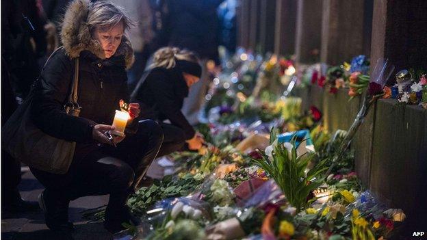 Woman lays flowers outside Copenhagen synagogue (15 Feb)