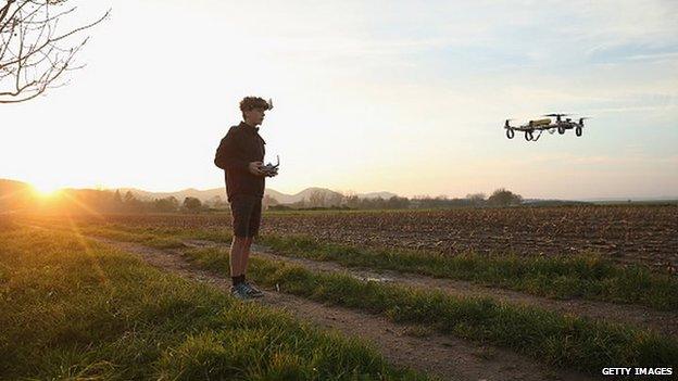 boy flies drone in a field