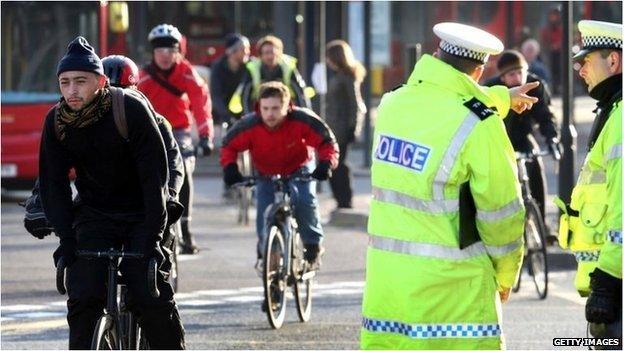 Police officers watch cyclists during Operation Safeway in November