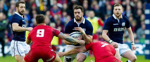 Alex Dunbar tries to break past Wales duo Rhys Webb and Sam Warburton