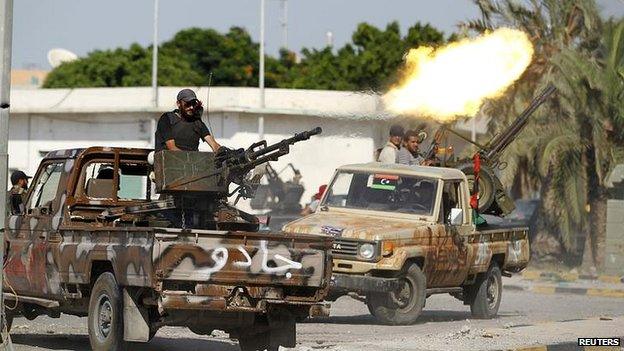 Libyan rebel fighter fires from vehicle towards Bab al Aziziya compound in Tripoli. 23 August 2011.