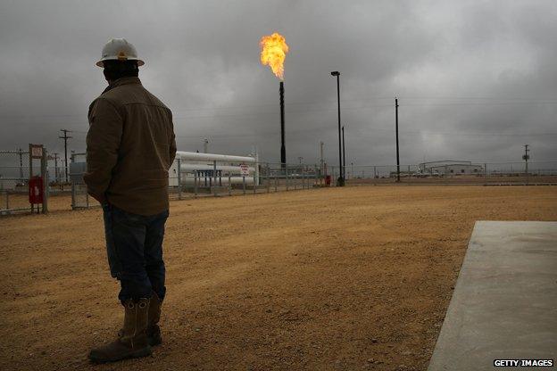 Texan oil worker contemplates flare from well