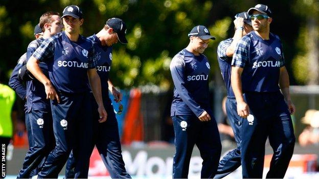 The Scotland cricket squad trudge off at the end of the defeat by New Zealand