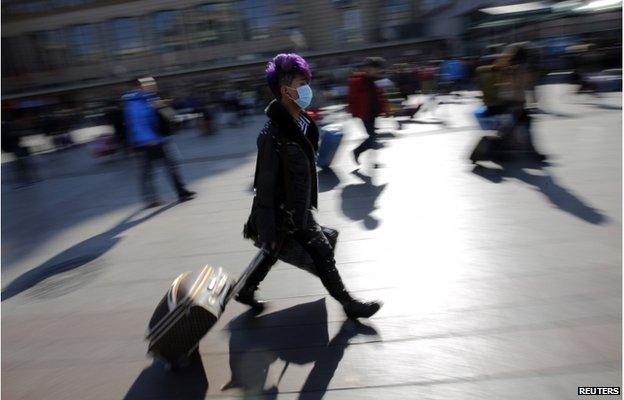 A man walks with his suitcase as he heads to a platform at a railway station in Beijing 17 February 2015.