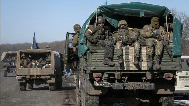 Ukrainian servicemen ride on a military vehicle as they leave area around Debaltseve, eastern Ukraine near Artemivsk, 18 February 2015