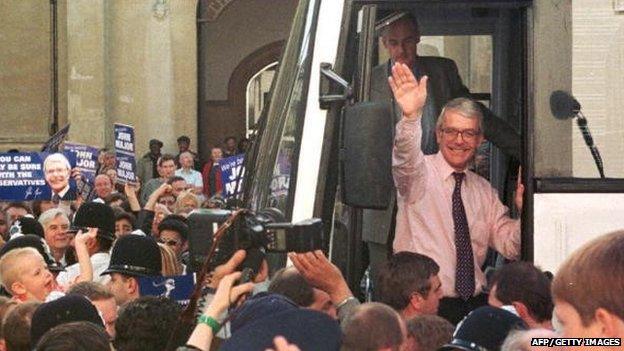 John Major waves to the crowd as he climbs into a bus