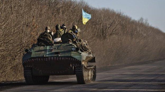 Ukrainian troops ride on an armoured vehicle outside Artemivsk, Ukraine, after pulling out of Debaltseve - 18 February 2015