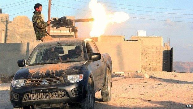 A fighter of Libya's Fajr Libya group (Libyan Dawn) fires his gun during clashes in the hill village of Kikla, southwest of Tripoli on 21 October 2014