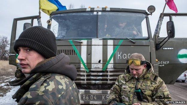 Ukrainian soldiers from a unit based in Zaporizhia repair their trucks after withdrawing from Debaltseve on 18 February 2015