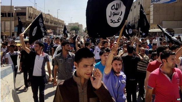 People chant pro-Islamic State group slogans as they carry the group's flags in Mosul in 2014