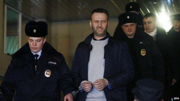 Anti-corruption blogger and liberal opposition leader Alexei Navalny (centre) is escorted into a police car outside Presnensky District Court, in Moscow (19 February 2015)