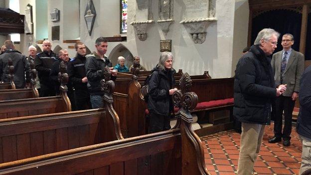 People line up to light candles during the service