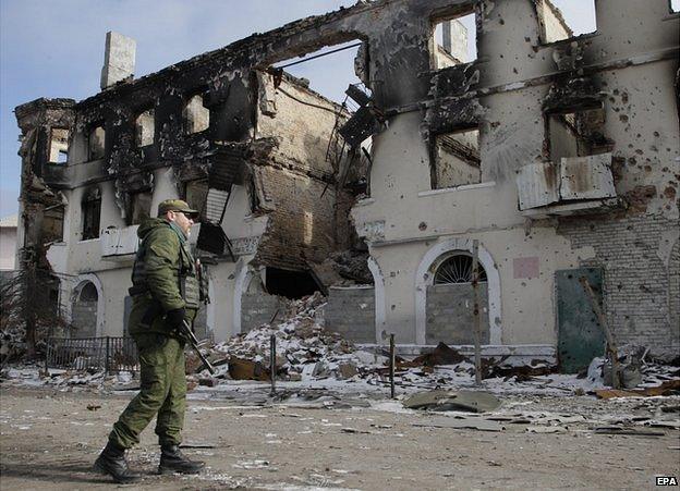 Vihlehirsk - rebel next to building ruined by shellfire