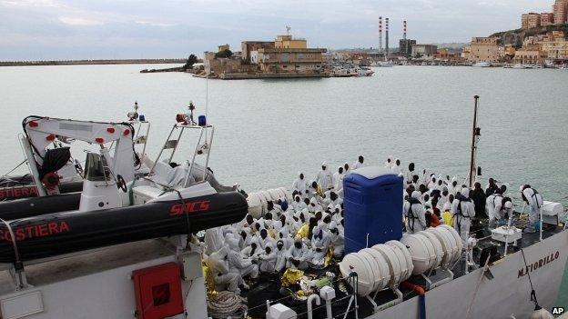 Migrants wait to disembark from an Italian Coast Guard ship after being rescued in Porto Empedocle, Sicily 14/02/2015