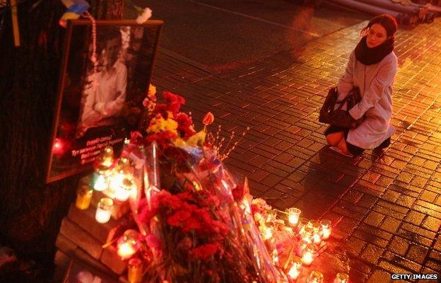 A woman kneels and weeps at a memorial in Kiev, Ukraine - 20 February 2015