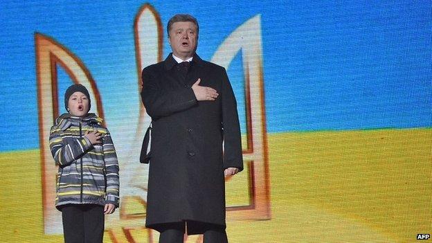 Ukrainian President Petro Poroshenko sings the state anthem with the son of a dead activist in Kiev - 20 February 2015