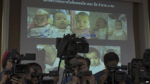 In this Aug. 12, 2014 file photo, the media cover as Thai police display pictures of surrogate babies born to a Japanese man who is at the center of a surrogacy scandal during a press conference at the police headquarters in Chonburi, Thailand