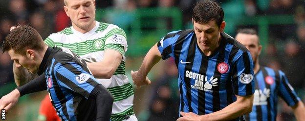 Martin Canning (right) challenges Celtic striker John Guidetti