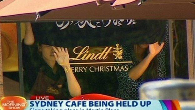 Hostages hold a banner during the Sydney cafe siege (December 2014)