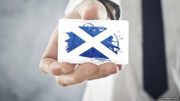 Businessman holding card with saltire