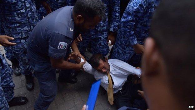 Maldives police try to move former president Mohamed Nasheed during a scuffle as he arrives at a courthouse in Male on 23 February 2015.