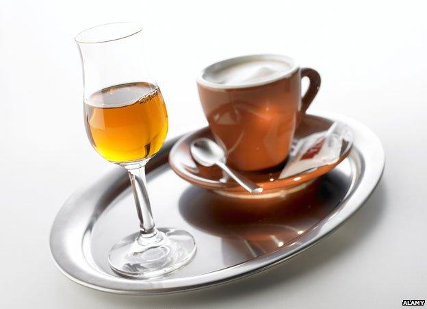 grappa glass with coffee in cup