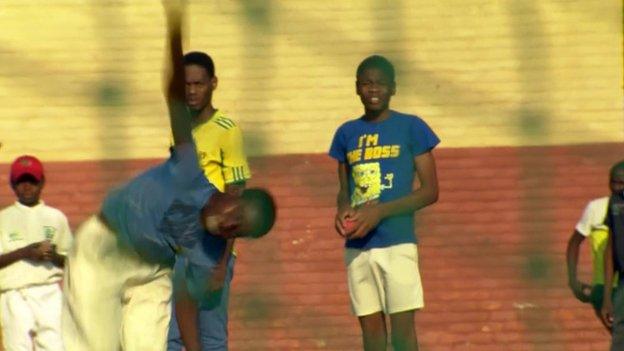 A boy practicing his bowl at a South African cricket club