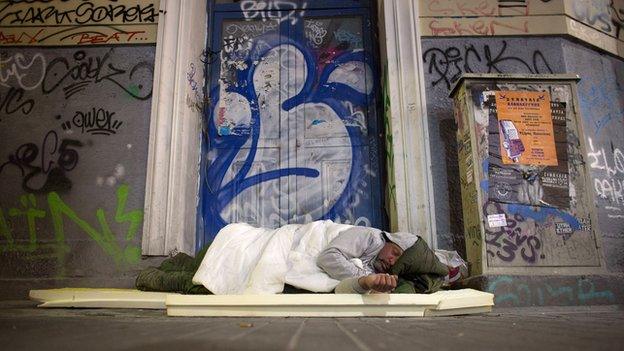 Homeless person sleeps in a doorway in Athens