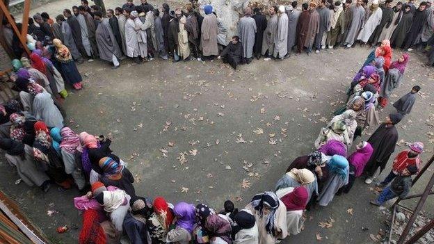 Kashmiri people wait in queues outside a polling station to cast their votes during the fourth phase of the state assembly election in Srinagar December 14, 2014.