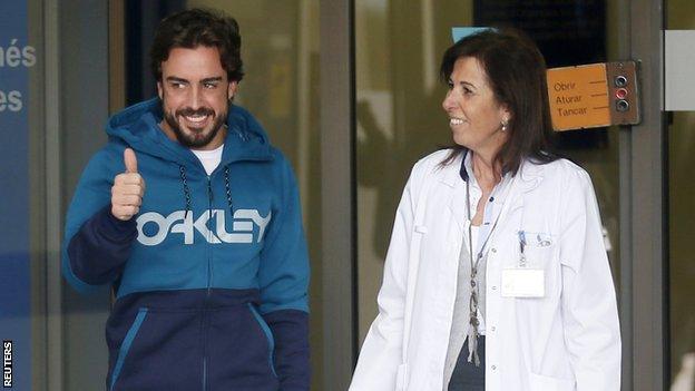 McLaren"s Formula One driver Alonso gestures to the media as he leaves a hospital where he has been hospitalized since Sunday, in Sant Cugat