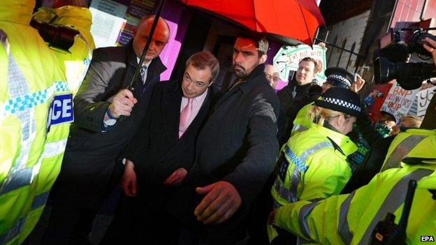 Nigel Farage leaves under police escort after a protest in Rotherham