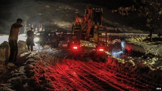 Afghan authorities remove snow from the roads as part of the rescue after an avalanche in the Panjshir valley, Afghanistan, 25 February