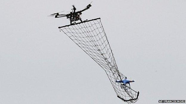 A drone Interceptor MP200, top, prepares to catch a drone DJI Phantom 2 with a net during a demonstration flight in La Queue-en-Brie