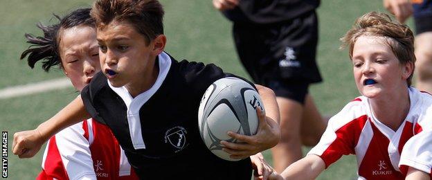 A New Zealand players runs with the ball against a Tonga side in a mini rugby tournament in Hong Kong in 2011