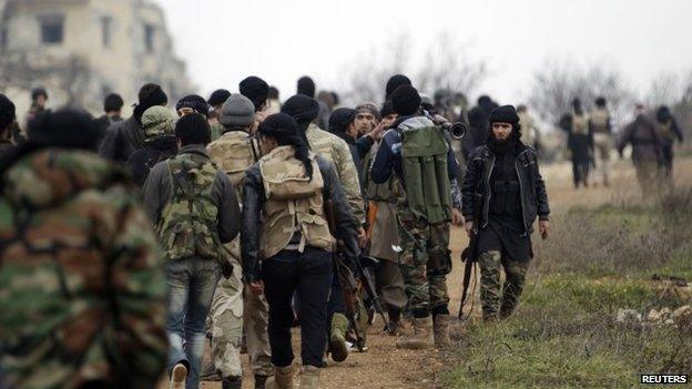 Fighters from Suqour al-Sham Brigade, which is part of the Free Syrian Army, walk with their weapons