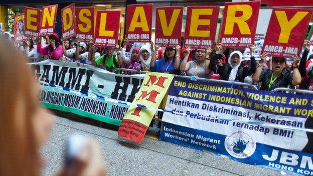 Members of a support group for Indonesian maids Erwiana Sulistyaningsih and Kartika Puspitari, who were abused by their Hong Kong employers, hold placards and shout slogans as they attend a protest outside the Indonesian consulate in Hong Kong on May 25, 2014.