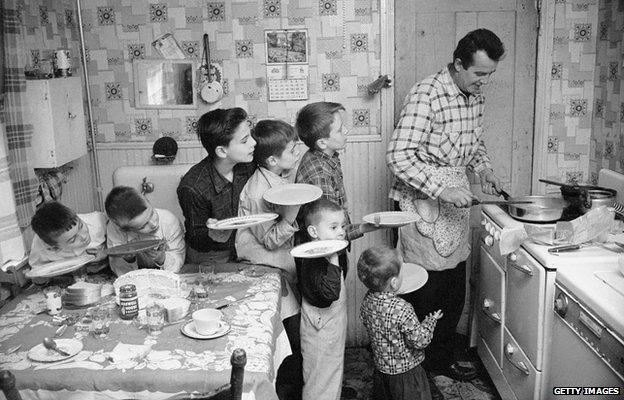 Seven siblings queuing for dinner, around 1955