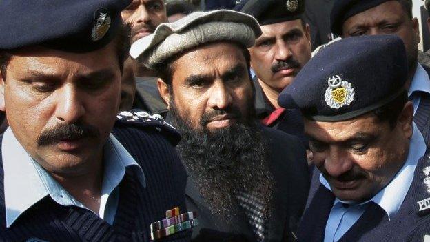 Pakistani police officers escort Zaki-ur-Rahman Lakhvi, center, the main sispect in the Mumbai terror attacks in 2008, after his court appearance in Islamabad, Pakistan, Tuesday, Dec 30, 2014