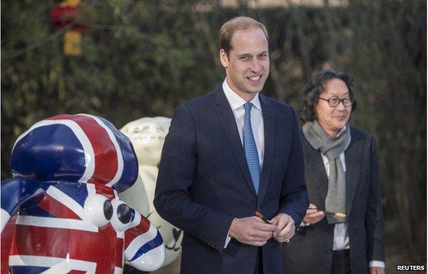 Britain's Prince William, Duke of Cambridge, poses after painting the eye of a "Shaun the Sheep" sculpture at the British Ambassador's official residence in Beijing, 2 March 2015