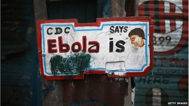 A sign, originally saying "Ebola is Real," hangs defaced in the West Point township in Monrovia