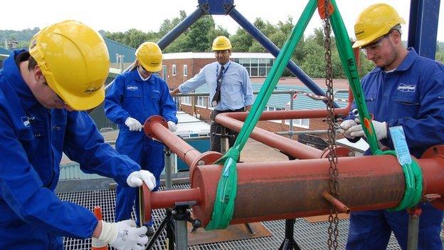 Apprentices fitting pipes