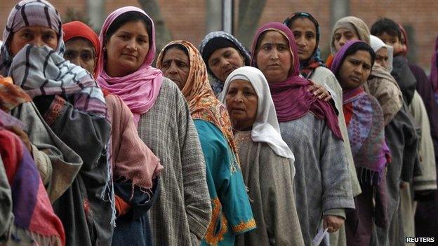 Kashmiri women wait in a queue outside a polling station to cast their votes during the fourth phase of the state assembly election in Srinagar December 14, 2014