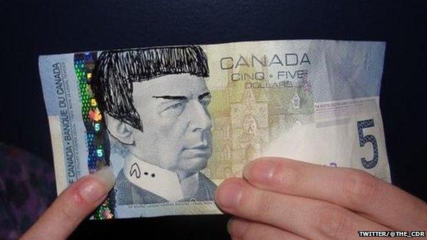 Someone holding a note with Spock's face drawn on