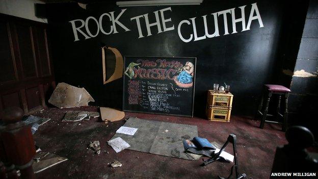 The stage - rock the Clutha backdrop, dusty leaflets, a music stand, a list of future gigs