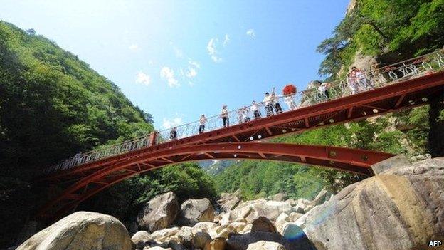 This photo taken on August 31, 2011 shows Chinese tourists admiring the view from a bridge along a path of a scenic spot at the Mount Kumgang international tourist zone in North Korea.