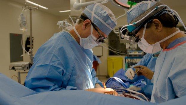 Surgeons performing heart operation (posed)