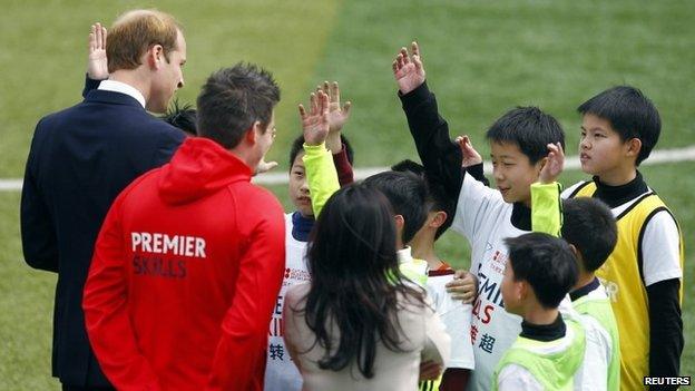 Prince William chats with students during a visit to Nanyang Secondary School